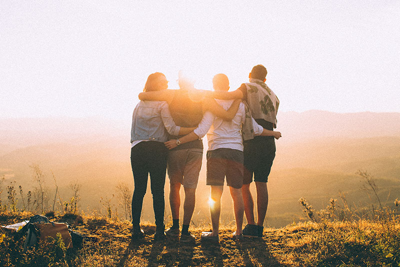 group of people standing at sunset